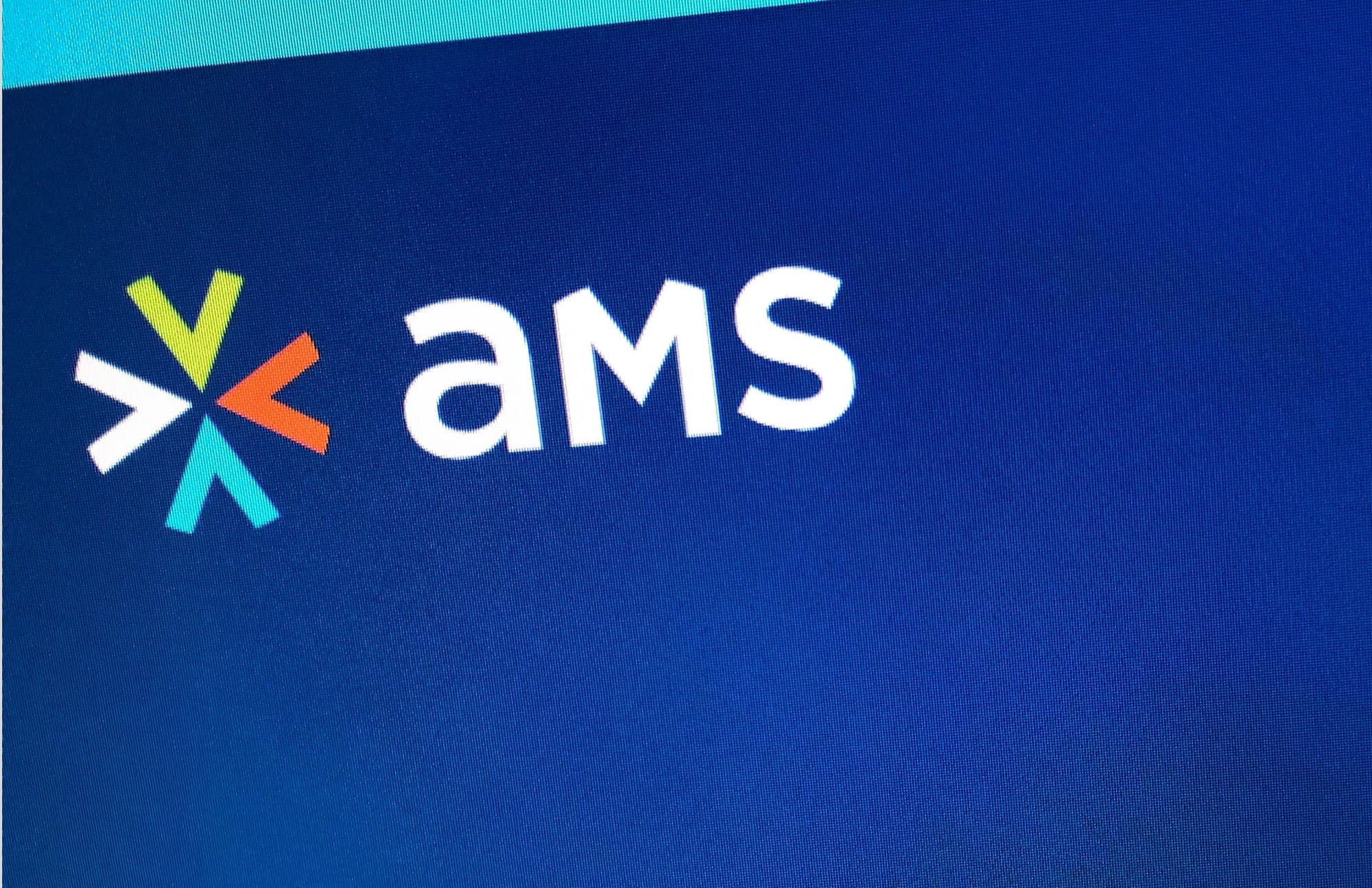 AMS identity printed on navy fabric with a multicolored chevron symbol